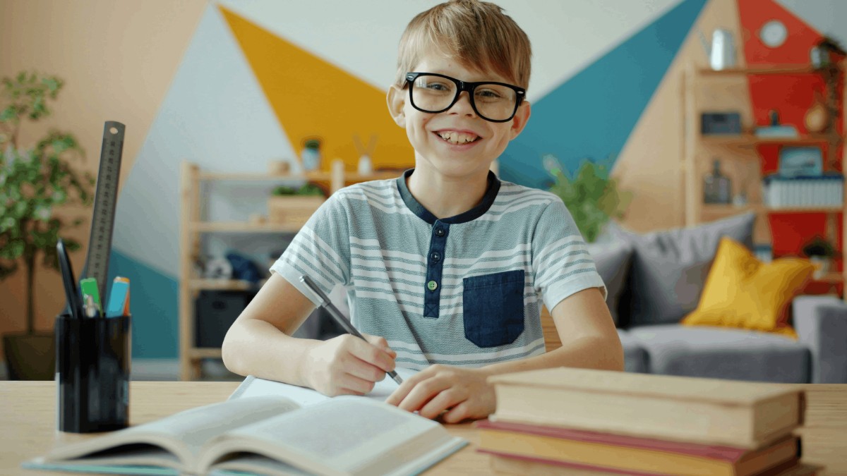 Smiling student writing in notebook during math lesson